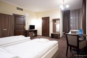 a hotel room with two beds and a desk at Hotel Lord Krosno in Krosno