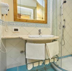 a bathroom with a sink and a mirror and towels at Locanda del Gagini in Palermo +15 photos
