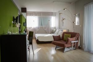 1 dormitorio con cama, silla, cama y ventana en Athens Habitat, en Atenas