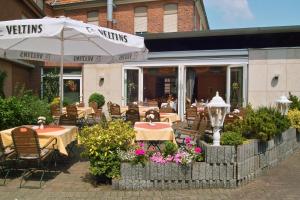 
a patio area with tables, chairs, and umbrellas at Hotel Restaurant Witte in Ahlen
