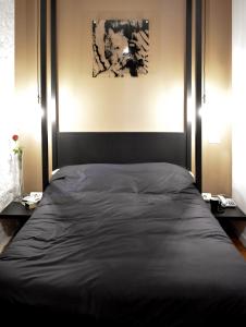 a bed in a bedroom with two tables and a picture at Bibi e Romeo's Home in Rome