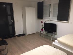 a living room with a television on a glass table at Apartment Ardi in Filderstadt