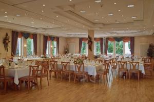 un salón de banquetes con mesas y sillas blancas en Hotel Restaurant Witte, en Ahlen