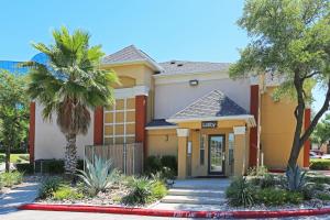 a house with a palm tree in front of it at Extended Stay America Suites - San Antonio - Airport in San Antonio