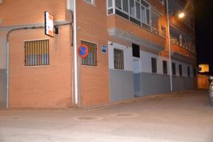 un edificio di mattoni rossi con un cartello stradale accanto di Hostal El Bugar a Teruel