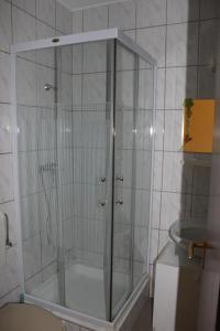um chuveiro com uma porta de vidro na casa de banho em Kovács Vendégház em Zalaegerszeg