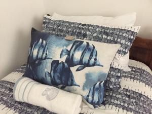a bed with blue and white pillows on it at Pebble Moon Holiday Flat in Strand