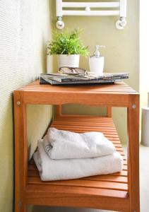 a wooden shelf with towels and a plant on it at Bibi e Romeo's Home in Rome