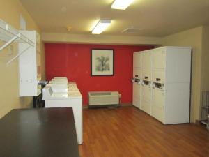 a room with a red wall and a room with machines at Extended Stay America Suites - Pleasant Hill - Buskirk Ave in Pleasant Hill