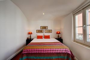 リスボンにあるGreat Duplex Apartment in Alfamaのベッドルーム1室(カラフルな毛布付きのベッド1台付)
