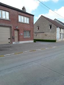 uma rua vazia em frente a dois edifícios de tijolos em Wenceslas Cobergher III em Bertem