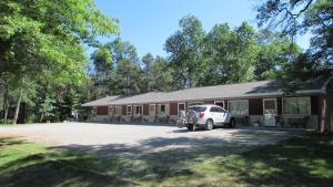 a car parked in front of a building at Woodland Motor Lodge in Grayling