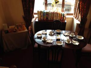 a dining room table with plates and dishes on it at Westgrange House Bed & Breakfast in Canterbury