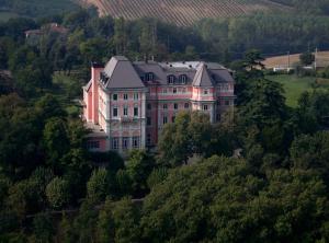 una casa grande en la cima de una colina con árboles en Relais Villa Pomela, en Novi Ligure