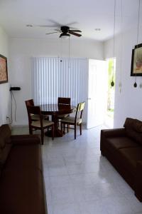 a living room with a dining room table and chairs at Casita Aurora in Chemuyil