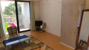 a living room with a couch a chair and a tv at Gracias in Kagoshima