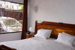 a bedroom with a bed with white sheets and a window at Family House in Lima