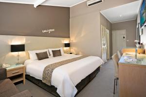 een hotelkamer met een groot bed en een bureau bij Best Western Sanctuary Inn in Tamworth