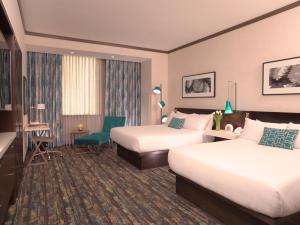 a hotel room with two beds and a chair at Thunder Valley Casino Resort in Lincoln