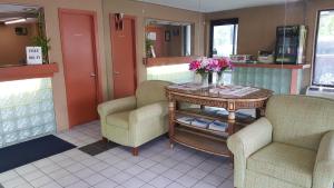 una mesa con dos sillas y una mesa con flores. en American Inn Columbia, en Columbia