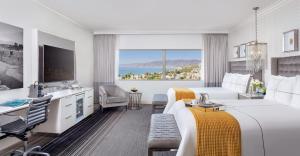 a hotel room with two beds and a desk at Huntley Santa Monica Beach in Los Angeles