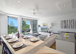 a kitchen and living room with a table and a couch at Allambi in Noosa Heads