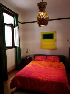 a bedroom with a red bed and a chandelier at Kolonaki Deco Apartment in Athens