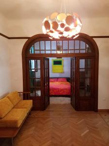 a living room with a bed and a chandelier at Kolonaki Deco Apartment in Athens