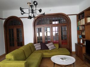 un salon avec un canapé vert et un lustre dans l'établissement Kolonaki Deco Apartment, à Athènes