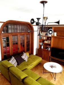 a living room with a green couch and a television at Kolonaki Deco Apartment in Athens