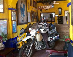 un hombre está sentado en una moto en una habitación en Pension California, en La Paz