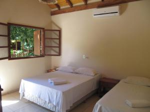 a bedroom with two beds and a window at Eco Pousada Villa Verde in Bonito