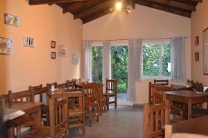 a restaurant with wooden tables and chairs and a window at Hotel Cristal in Tandil