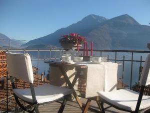 uma mesa e cadeiras numa varanda com montanhas em Il Terrazzino em Musso