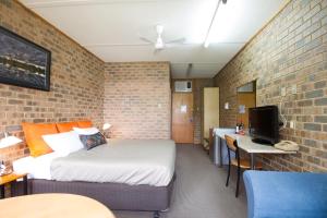 マナムにあるMannum Motelのベッドとテレビ付きの机のある寝室 +13枚の写真