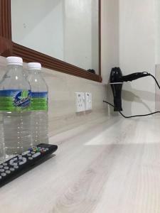 a bottle of water and a remote control on a counter at Tambun Inn Hotel in Ipoh