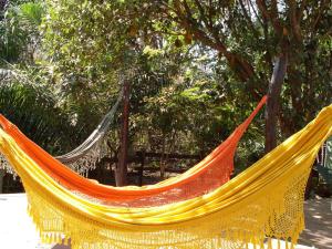 un hamac jaune et orange devant les arbres dans l'établissement Eco Pousada Villa Verde, à Bonito