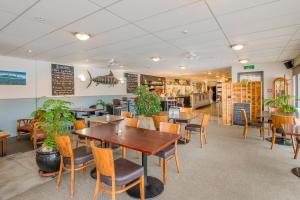 um restaurante com mesas e cadeiras e uma cafetaria em Finns Paekakariki em Paekakariki