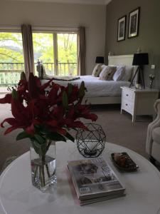 a vase of red flowers on a table in a bedroom at Emerald Ridge in Emerald