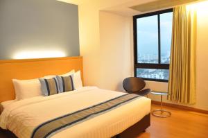 een slaapkamer met een bed en een groot raam bij Iyarin @ Tuk Chang Hotel in Bangkok +29 foto's