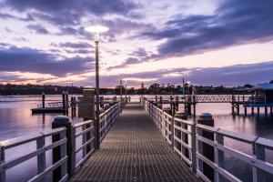 a pier with a street light on the water at Coast Resort Merimbula in Merimbula