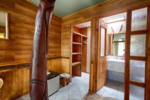 uma casa de banho com paredes de madeira e uma banheira em Hotel Manavai em Hanga Roa