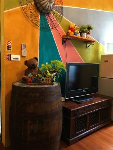 un oso de peluche sentado en la parte superior de un barril junto a una televisión en Hualien Paris Home B&B, en Hualien City