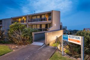 un edificio con una señal delante de él en Horizon Holiday Apartments, en Narooma