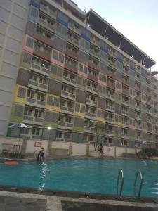 a pool in front of a large apartment building at DSR Apartment Margonda Residence 2 in Depok