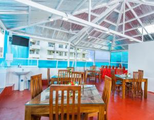 a restaurant with wooden tables and chairs and a sink at My Holiday Ticket in Colombo