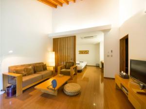 a living room with a couch and a bed at Yamado in Nishiwaga