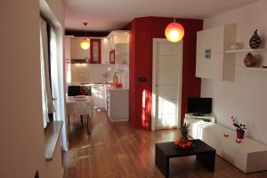 sala de estar y cocina con paredes rojas y blancas en Apartment Jasna, en Poreč