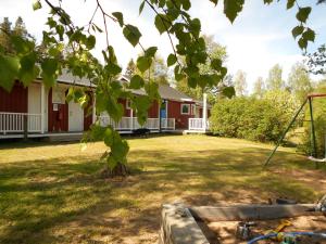 a house with a yard with a swing at Söderhagen Camping och Gästhem in Eckerö