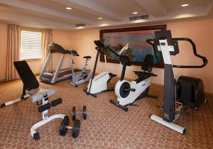 einen Fitnessraum mit mehreren Heimtrainern und einem TV in der Unterkunft Sandpiper Lodge - Santa Barbara in Santa Barbara